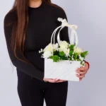 Devojka drži torbicu sa krem ružama, belim i zelenim margaretama – Cvećara Nena
