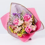 Buket sa roze ruzama, alstromerijama, staticom i gipsofilom – pogled direktno na aranzman.