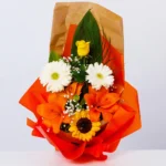 Buket sa ružama, gerberima, ljiljanima i suncokretima – pogled direktno na aranžman.