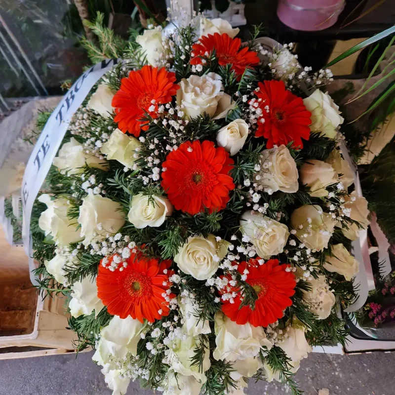 Detalj većeg venca za sahrane sa belim ružama i crvenim gerberama