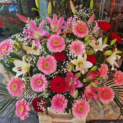 Dekorativna korpa sa gerberima, ljiljanima i listovima palme