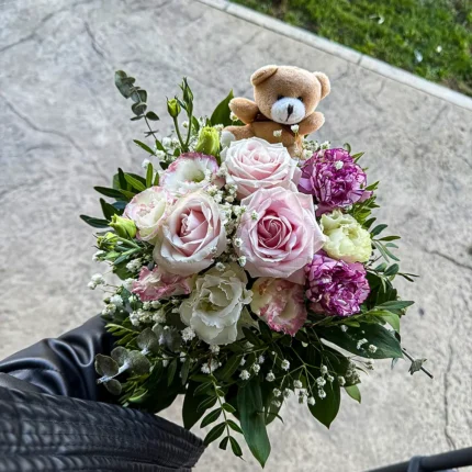 Detalj buketa sa ružama, karanfilima i plišanim medom