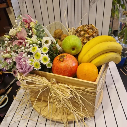 Detalj voćne gajbe sa cvetnim aranžmanom