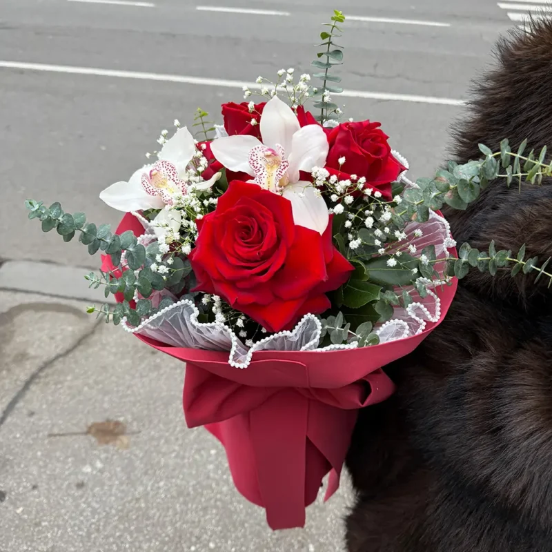 Detalj novogodišnjeg buketa sa crvenim ružama, belim orhidejama i gipsofilom